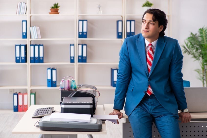 Young employee making copies at copying machine